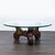 Mid-Century table with Mediterranean style carved wood base. Dimensions (in): 44W x 44D x 17H.