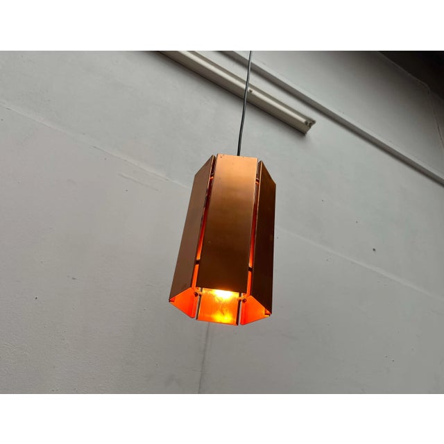 Three mid-century copper pendant lights. The simple pendant lights feature the basic shape of a hexagon. The copper...