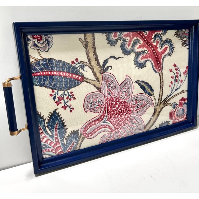 A beautifully tailored vintage serving tray featuring a deep navy lacquered frame, brass side handles, and a floral fabric...