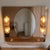 A rare and dramatic illuminated wall mirror with a shelf and integrated side sconces in amber/peach cut glass, a...
