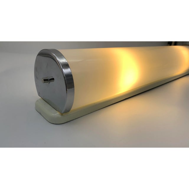 They are a pair of glass wall lights with a modern and linear design, characterized by a horizontal tubular structure that...