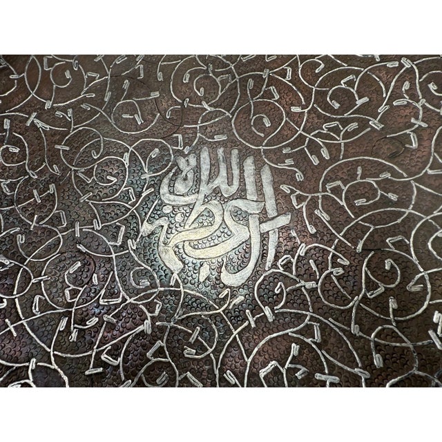 This thick antique handmade Middle Eastern sterling silver inlay over copper decorative plate is a unique and ornate piece...