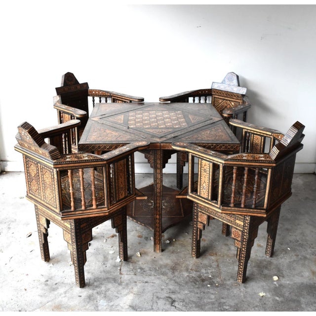 An antique, late-19th to early-20th-century Syrian card table set with four matching chairs. Intricate Syrian marquetry or...