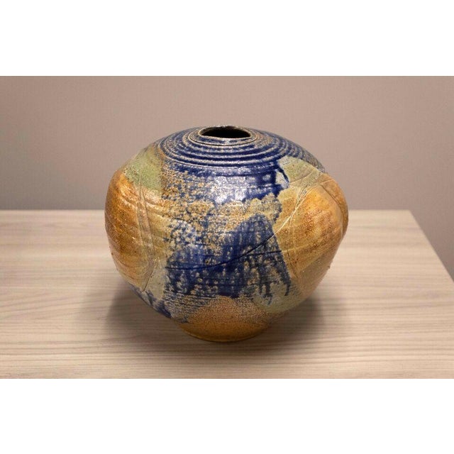 Behold the earthy charm of this "Blue and Brown Glazed Pottery Vessel," a piece that exemplifies mid-century modern...