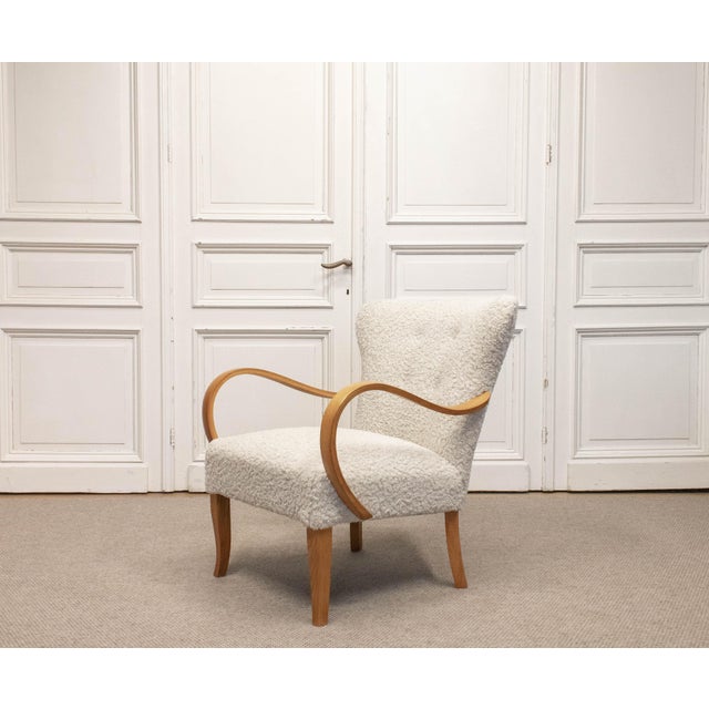 This elegant designer lounge chair dates from the 1950s and originates from Sweden. It features a refined elm wood frame...