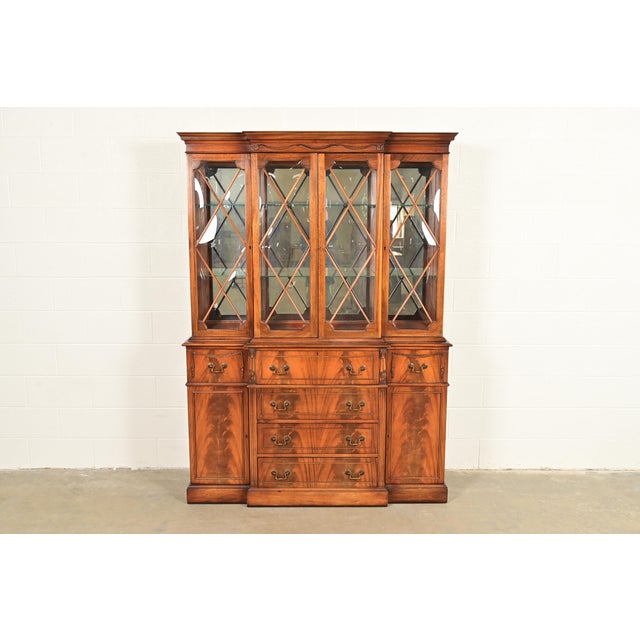 A beautiful Regency or Georgian style lighted breakfront bookcase or dining cabinet with drop front secretary desk In the...
