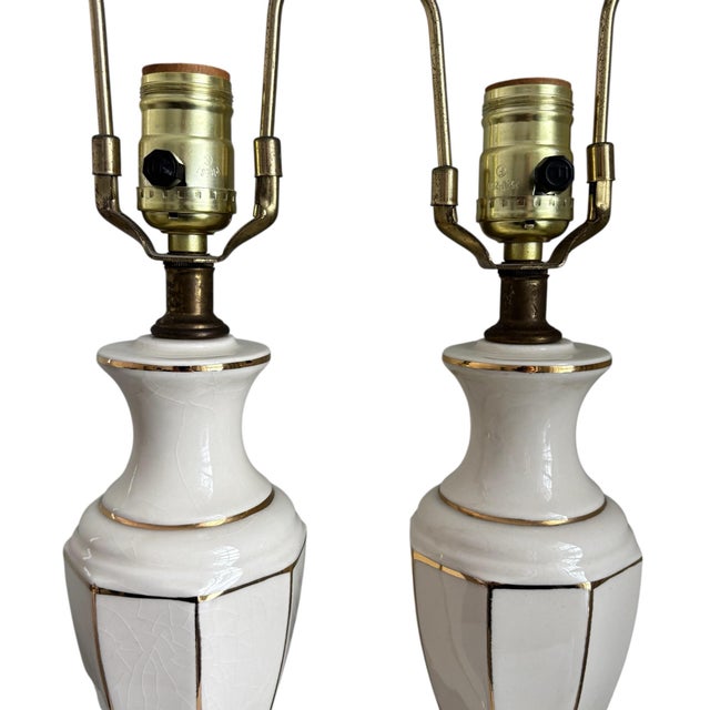 Absolutely stunning pair of Hollywood Regency elegant cream porcelain table lamps with gold brass base. In excellent...