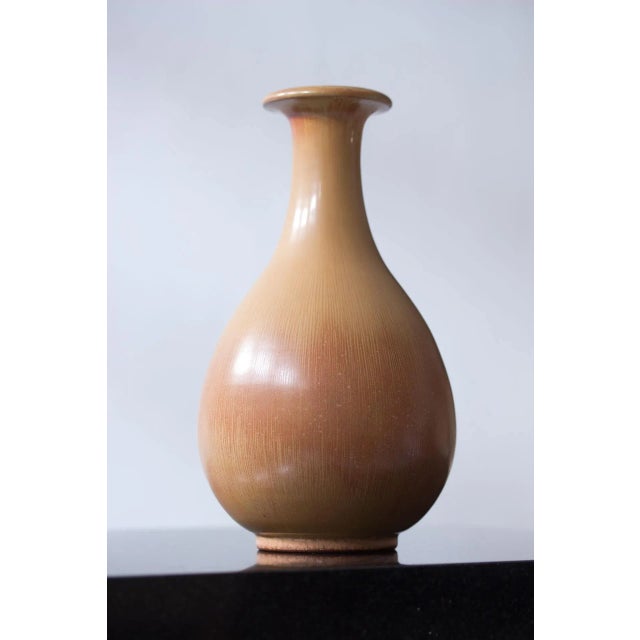 Stoneware vase designed by Gunnar Nylund, manufactured by Rörstrand during the 1940s. Hare fur glaze in sand to red ochre...