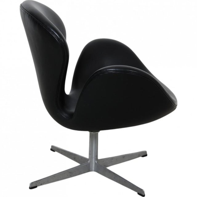 Arne Jacobsen Swan chair upholstered in black leather and with a swivel base of aluminum. The chair is from the 1960-1970s...
