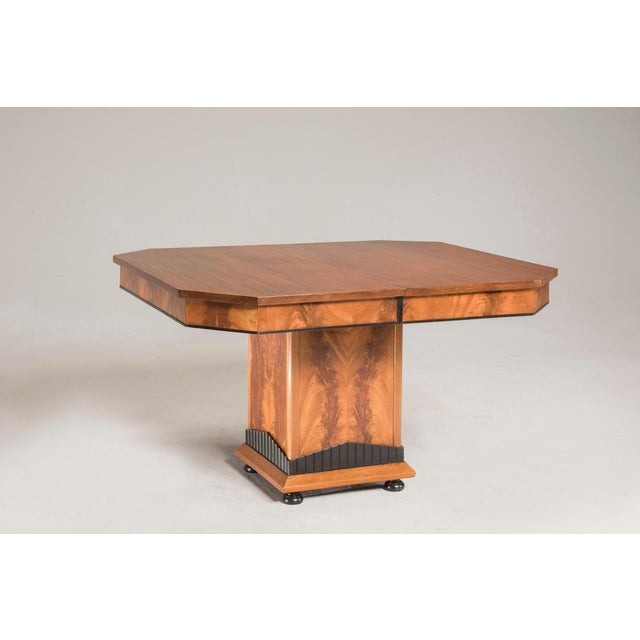 Art Deco wood squared extendable table with black ebonized details. The central leg has lot of beautiful wood veneer. When...