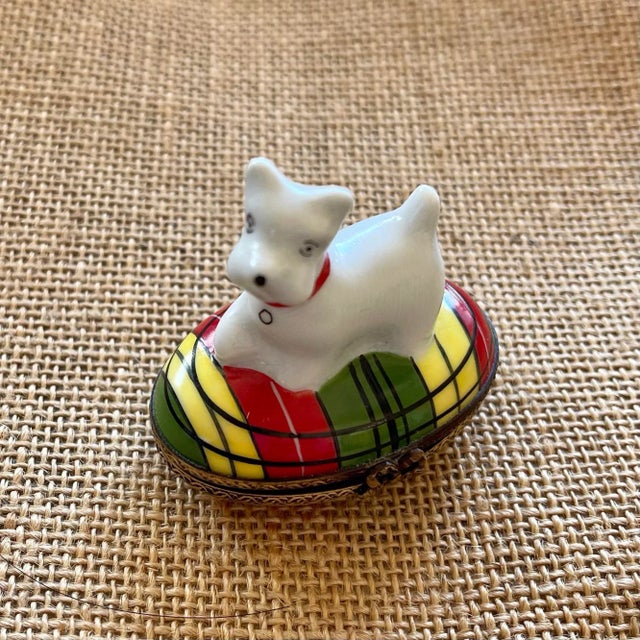 A delightful Scottie dog with a red collar sitting on a tartan pattern. Inside the box has a small painted bone and...