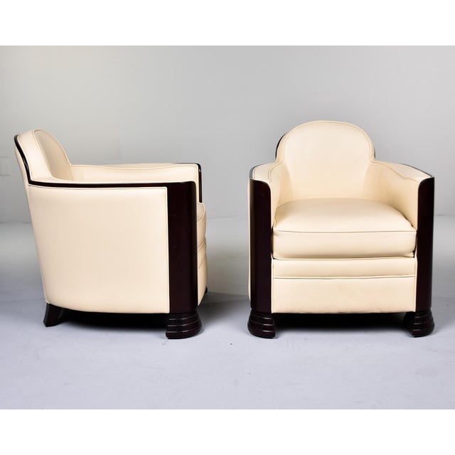 This pair of French Art Deco club chairs embodies the movement's defining geometry. Each chair features the iconic tub...