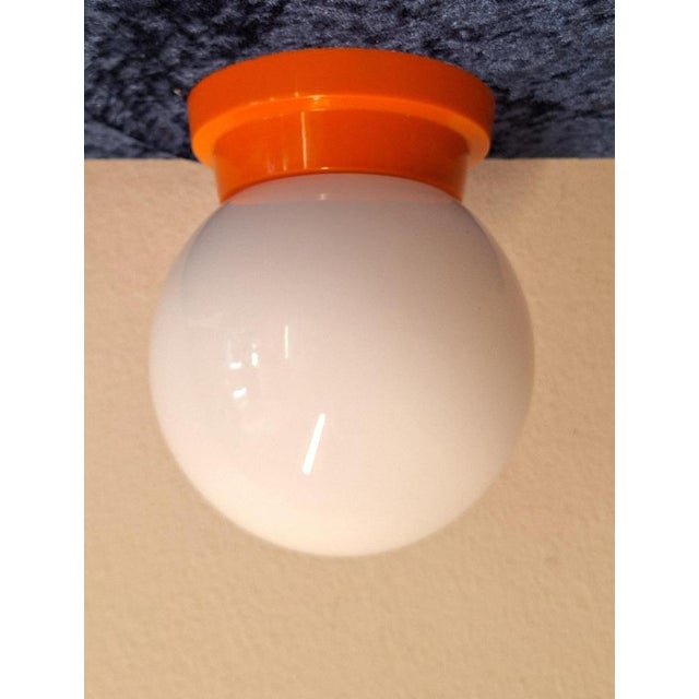 Flat Vintage Ceiling Lamp with Opaque White Glass Shade on Orange Plastic Mount, 1970s, in Very Good conditions. Designed...
