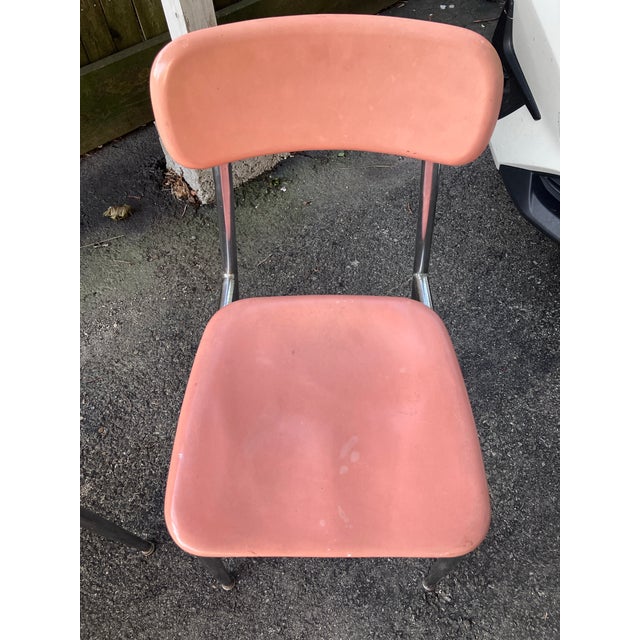 Set of three vintage MCM Heywood Wakefield molded plastic and chrome school chairs. Two are pink, one is cream colored....