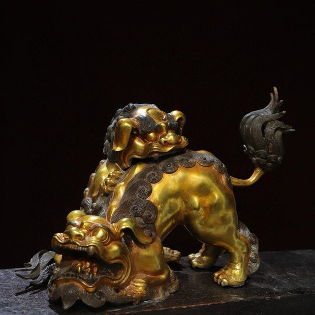 This impressive gilt bronze incense burner features a dynamic guardian lion in a playful yet protective pose. The lion is...