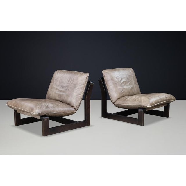A striking pair of leather sling lounge chairs by Dreipunkt International, Germany, dating from the 1970s. Combining dark...