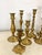 Assorted lot of 9 Traditional brass candlesticks. The heights range from 4.75”H to 12.25” tall. Ornate and classic in...