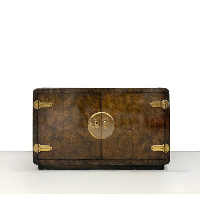 A beautifully crafted vintage sideboard featuring a richly figured burl wood veneer framed by softly rounded edges. The...