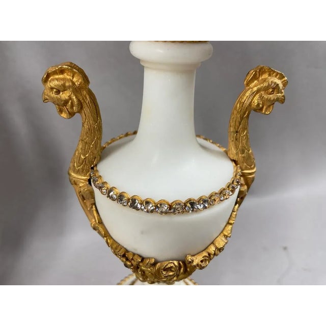 Pair of 19th Century French Louis XVI White Marble and Bronze Candelabras Bring timeless grandeur into your home with this...