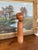 This vintage Japanese Kokeshi doll features a minimalist cylindrical form with a rounded head and hand-painted facial...