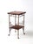 This is an antique wood and brass side table. The Victorian era stand features a decorative brass frame, paw feet, with a...