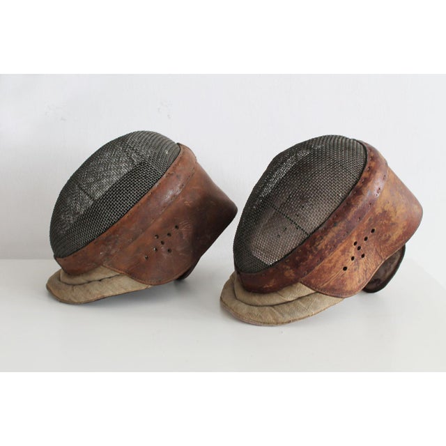 This is an original par of fencing mask believed to be produced in France in the 1920's. Both masks are made of rich brown...