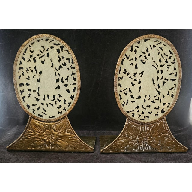 A beautifully crafted pair of antique Chinese carved jade bookends, each featuring an oval pierced jade panel mounted in...