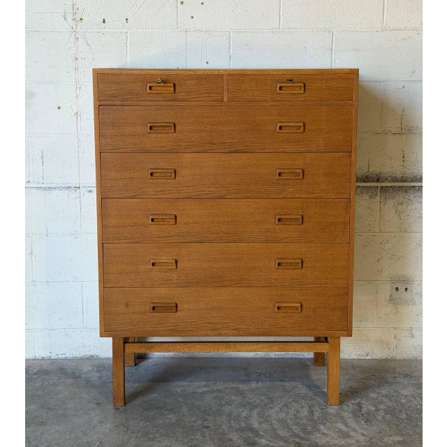 This tall chest features clean Scandinavian lines and multi-drawer storage. The piece showcases iconic Danish Mid-Century...