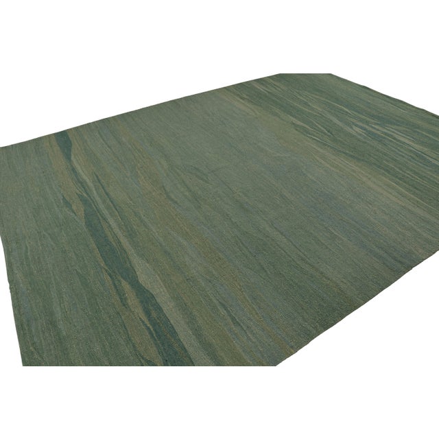 Hand-knotted in wool, this 9x12 modern kilim rug in paddle-weave style, in teal, has subtle geometry in a muted,...