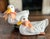 Created by Earth Needs Ltd. of Petaluma California in 1983. Terra cotta glazed ducks with glass eyes and ribbon bow...
