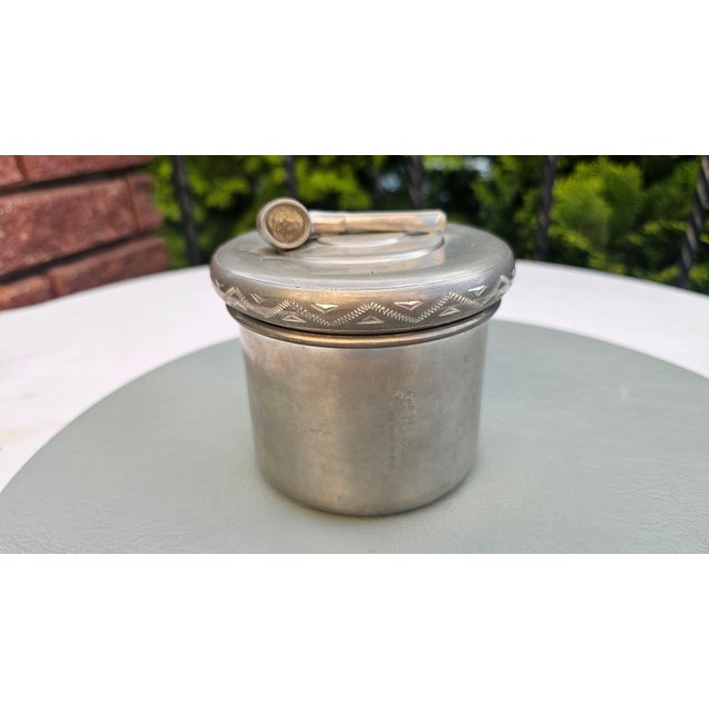 Pewter tin for snuff or tobacco, featuring a pipe on the lid; dates from the 1950s–1970s, d imensions: height 11.5 cm,...