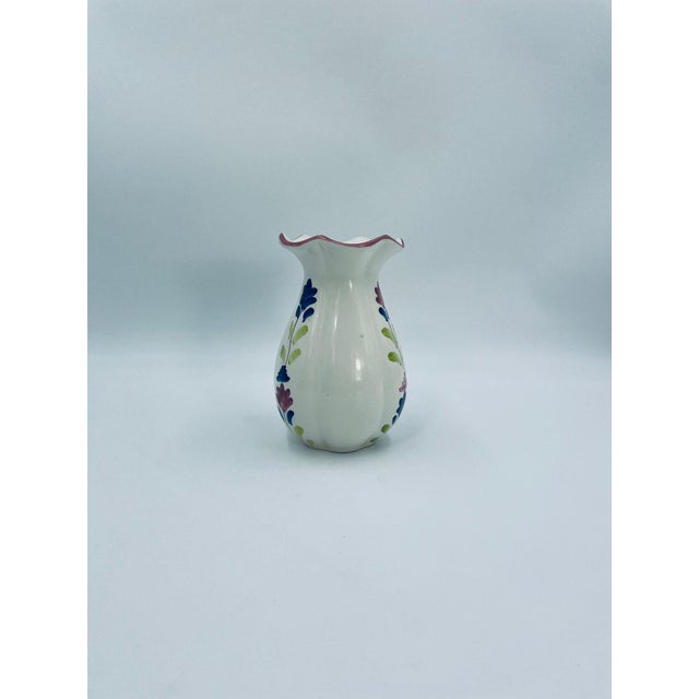 A decorative vintage vase made of high-quality cream-colored ceramic. The vase features a bulging belly, tapered neck, and...