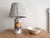 Sweet small vintage ceramic lamp with colorful fruit transferware on front Lamp has an off white background with dark...