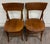 This is a striking pair of antique bent oak dining chairs dating to the early 20th century. Each features a broad curved...