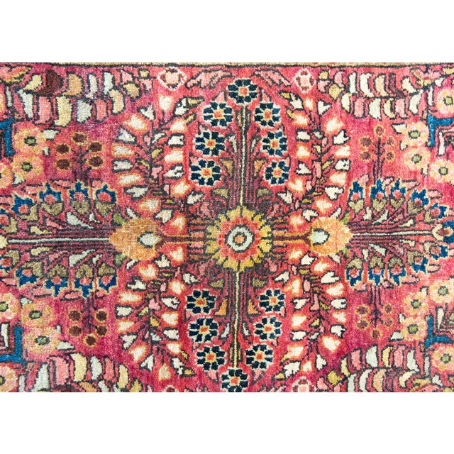 A charming petite early 20th century Persian Sarouk rug with a mirrored floral pattern, surrounded by a simple border with...