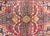 A charming petite early 20th century Persian Sarouk rug with a mirrored floral pattern, surrounded by a simple border with...