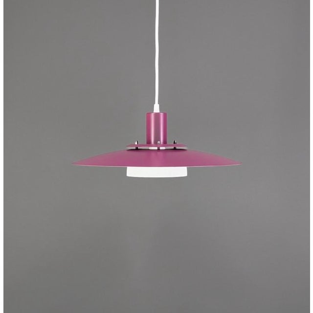 A refined Danish pendant lamp from the 1970s, featuring a beautifully balanced composition of soft plum-purple lacquered...