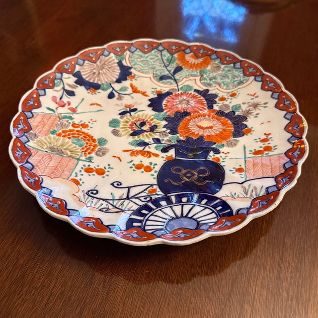 A turn-of-the-century Japanese Amari charger with scallop rim, and Famille rose colors. Iron oxide, red with cobalt blue...