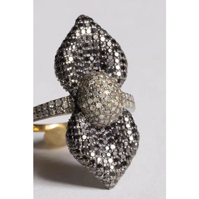 An extraordinary cocktail ring featuring a double petal flower motif, or maybe a bow, comprised of round, brilliant cut...
