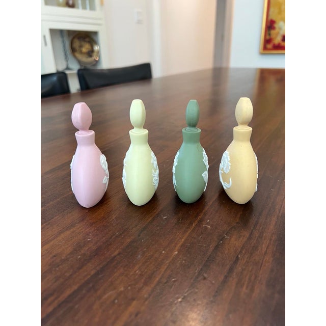 Lot of four vintage 1978 Porcelaine Franklin perfume bottles featuring jasperware-style raised white floral reliefs...