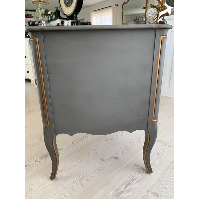Here we have a lovely vintage French style writing desk in old grey paint with gold trim. I find no maker's mark, but feel...