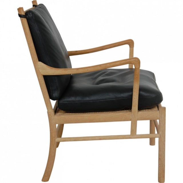 Ole Wanscher Colonial chair with a frame of oak and cushions upholstered in black leather. The chair is from around 2010...