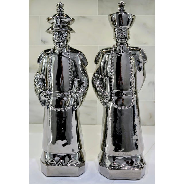 Striking large vintage Chinoiserie figurine pair in high‑gloss chrome‑plated porcelain, depicting a scholarly elder and...