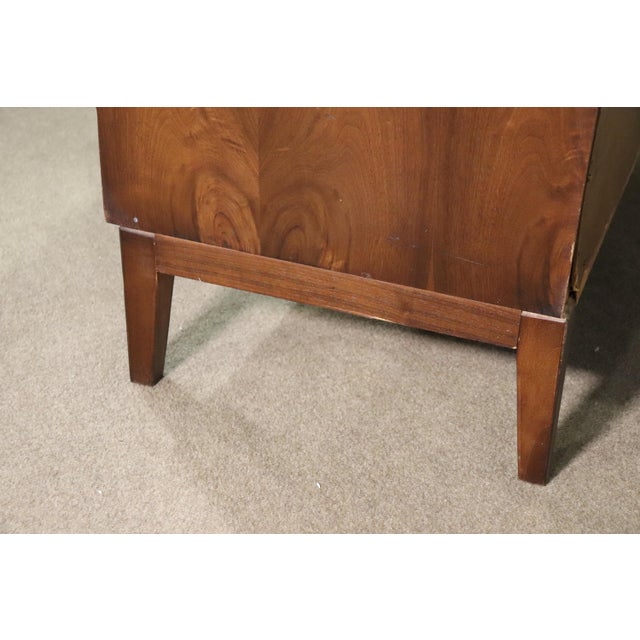 Mid-century modern dresser with nine drawers, curved front, and burl veneer.