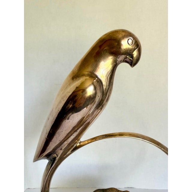 Here is a wonderful, sculptural decor piece featuring a parrot perched on a round handle, looking over a central dish. The...
