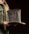 Large-scale tin top hat form with exaggerated proportions, featuring a tall cylindrical crown and wide, gently flared...