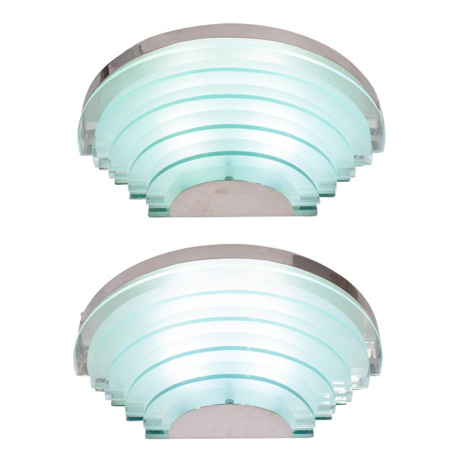 A bold pair of large wall sconces presenting a dramatic semi-circular, tiered silhouette. Designed to make a statement...