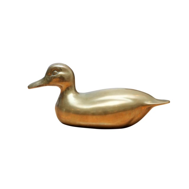 An ornamental brass duck, simply pressed with eye and beak details. Curves are suggestive of wings and the piece is...