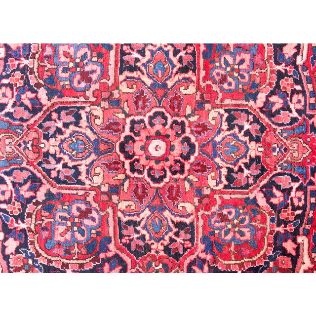This mid-20th-century Persian Heriz rug features a bold, geometric medallion design characteristic of the Northwest...