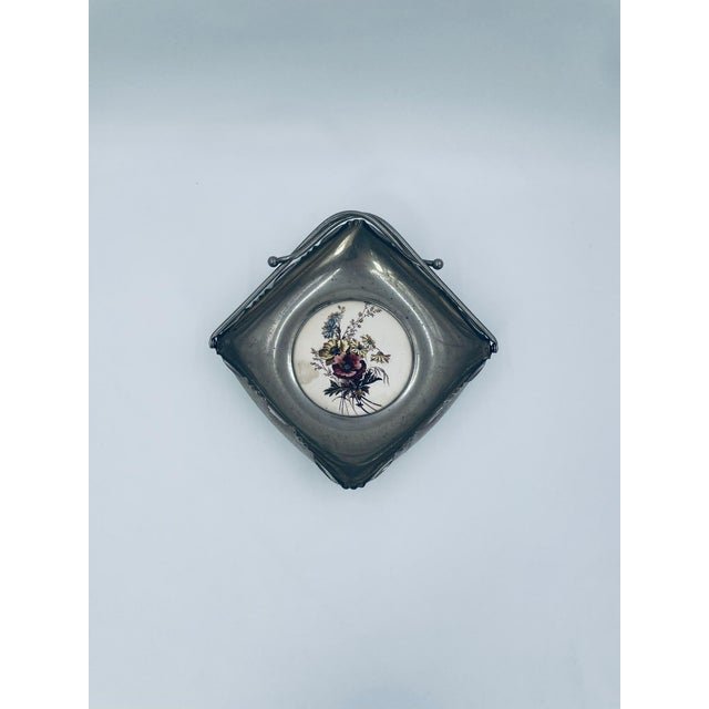 Vintage-style decorative basket. The basket is made of silver-colored metal with a movable handle. The center is made of...